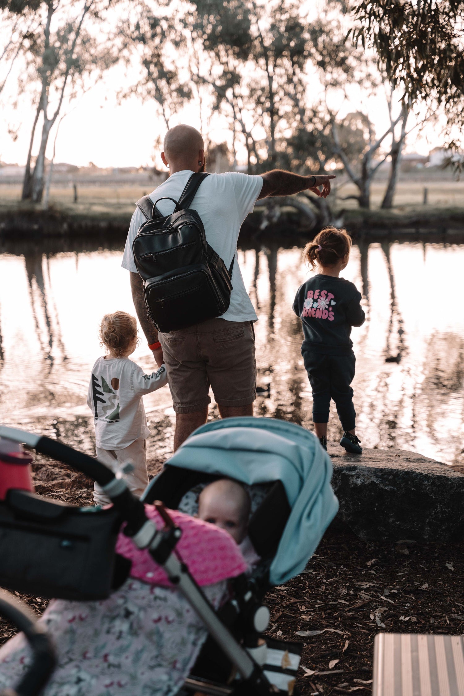 Happy family moments, father and young children by a river
