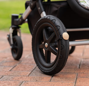 Close up of a Lullabump on a pram Wheel. A Baby soothing pram attachment for naps on the go.
