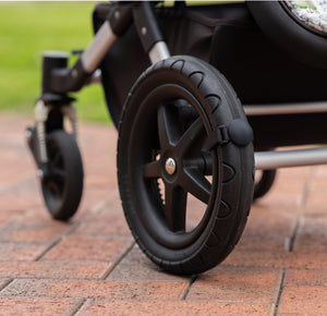 Close up of a Lullabump on a pram Wheel. A Baby soothing pram attachment for naps on the go.