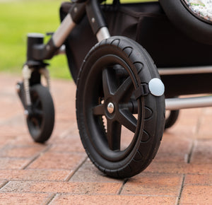 Close up of a Lullabump on a pram Wheel. A Baby soothing pram attachment for naps on the go.