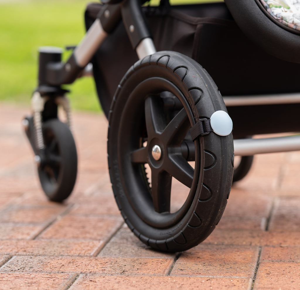 Close up of a Lullabump on a pram Wheel. A Baby soothing pram attachment for naps on the go.